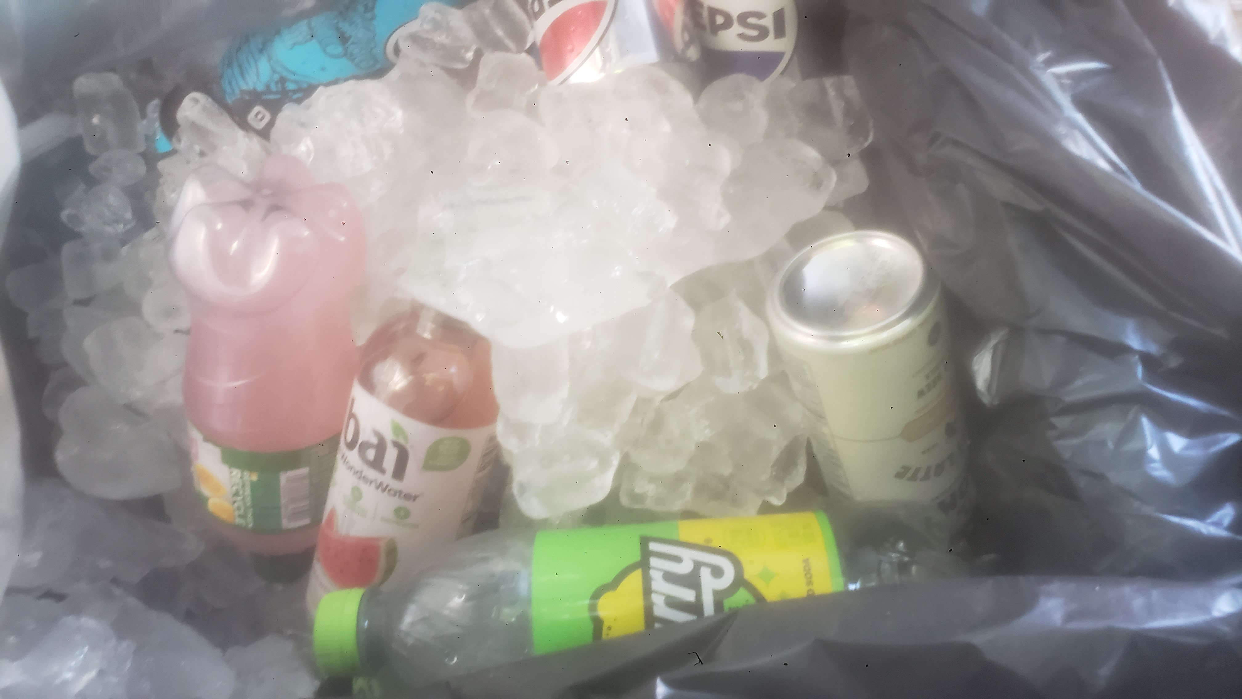 Bottles in ice on a trash bag.